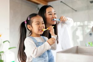 mother and daughter brushing teeth